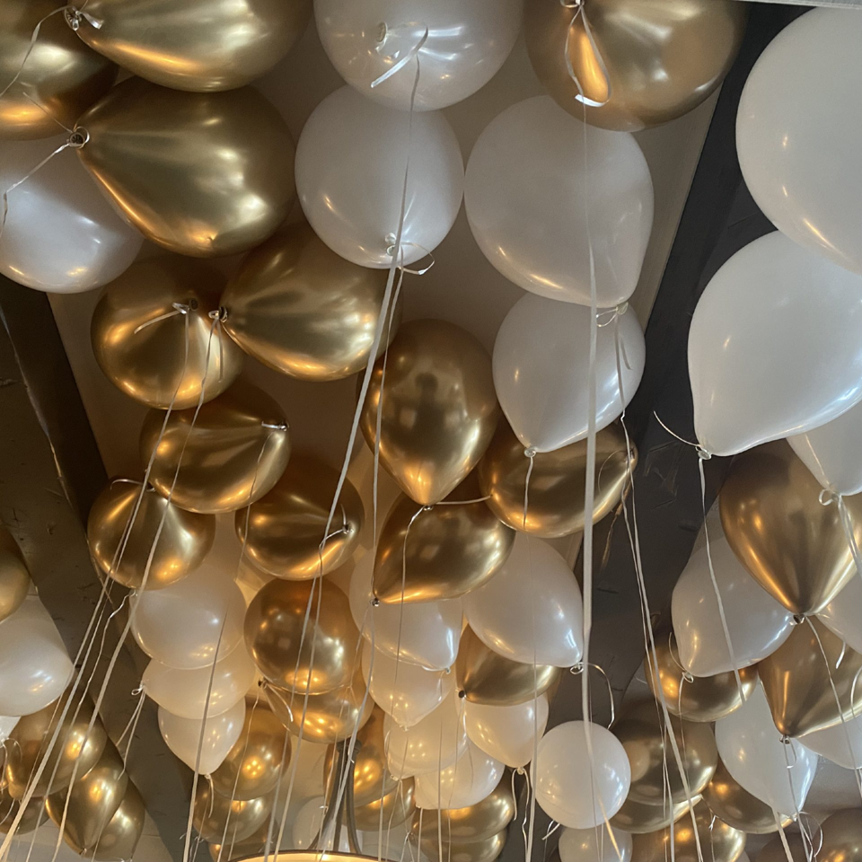 Gold and white balloons decorating the ceiling