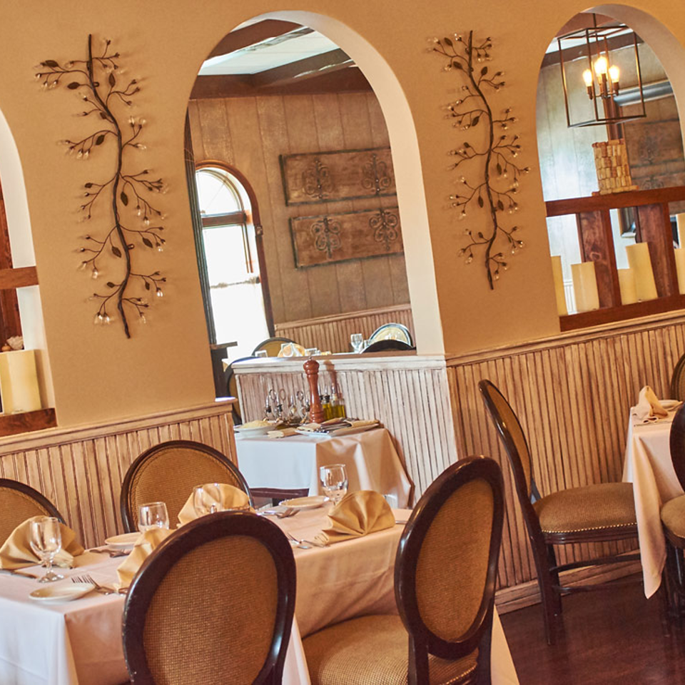 Dining room with arched openings and white tablecloths