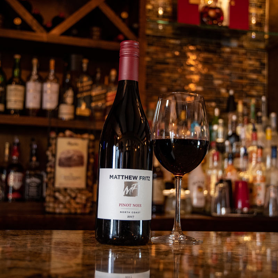 Pinot Noir bottle and glass at the bar